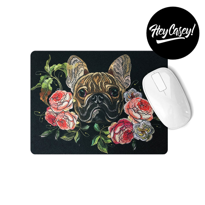 Black mouse pad with a print of a needlework French bulldog and flowers